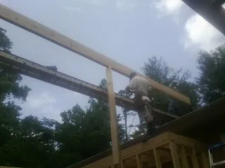 Carpenter setting a ridge beam over a new addition frame — Ice Dam Removal by Roofing Brothers in Alamosa
