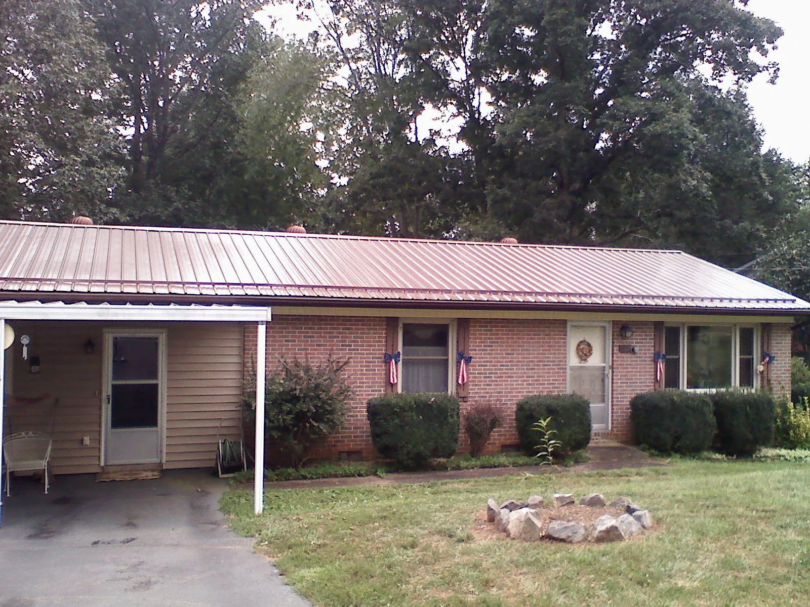 Bronze metal roof and carport on a brick ranch home — Roof Repair work by our crew in Alamosa